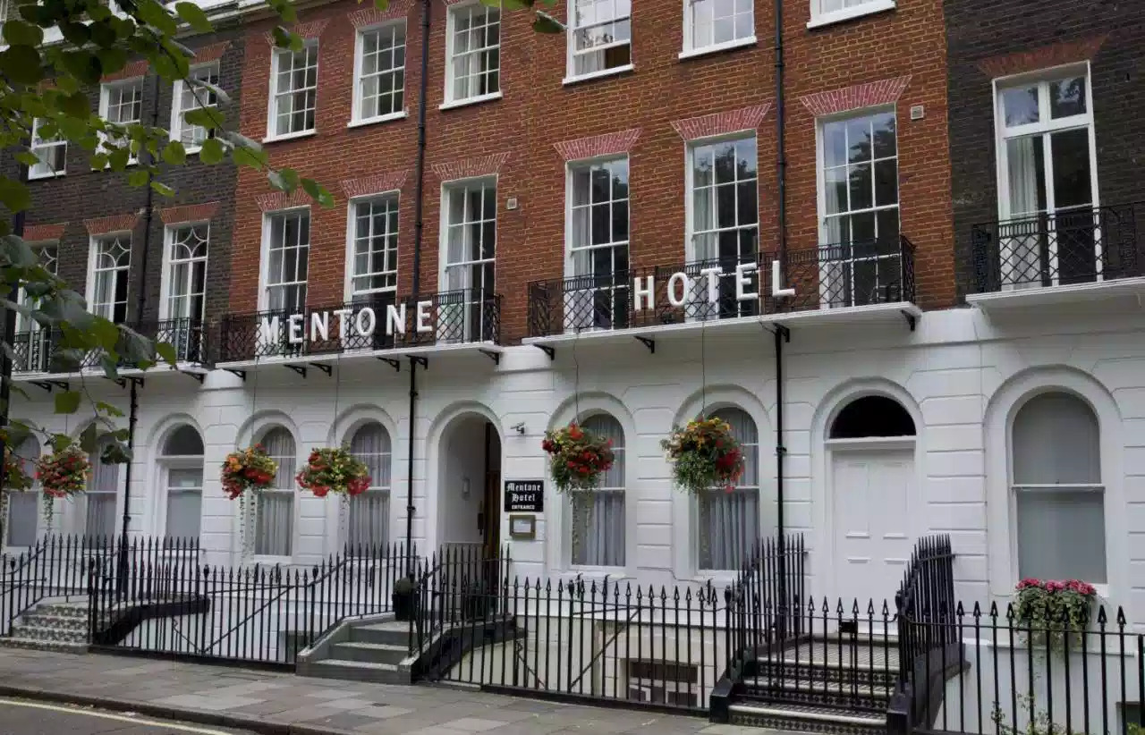 Exterior of The Mentone Hotel with a clear sign indicating the hotel's name at the entrance