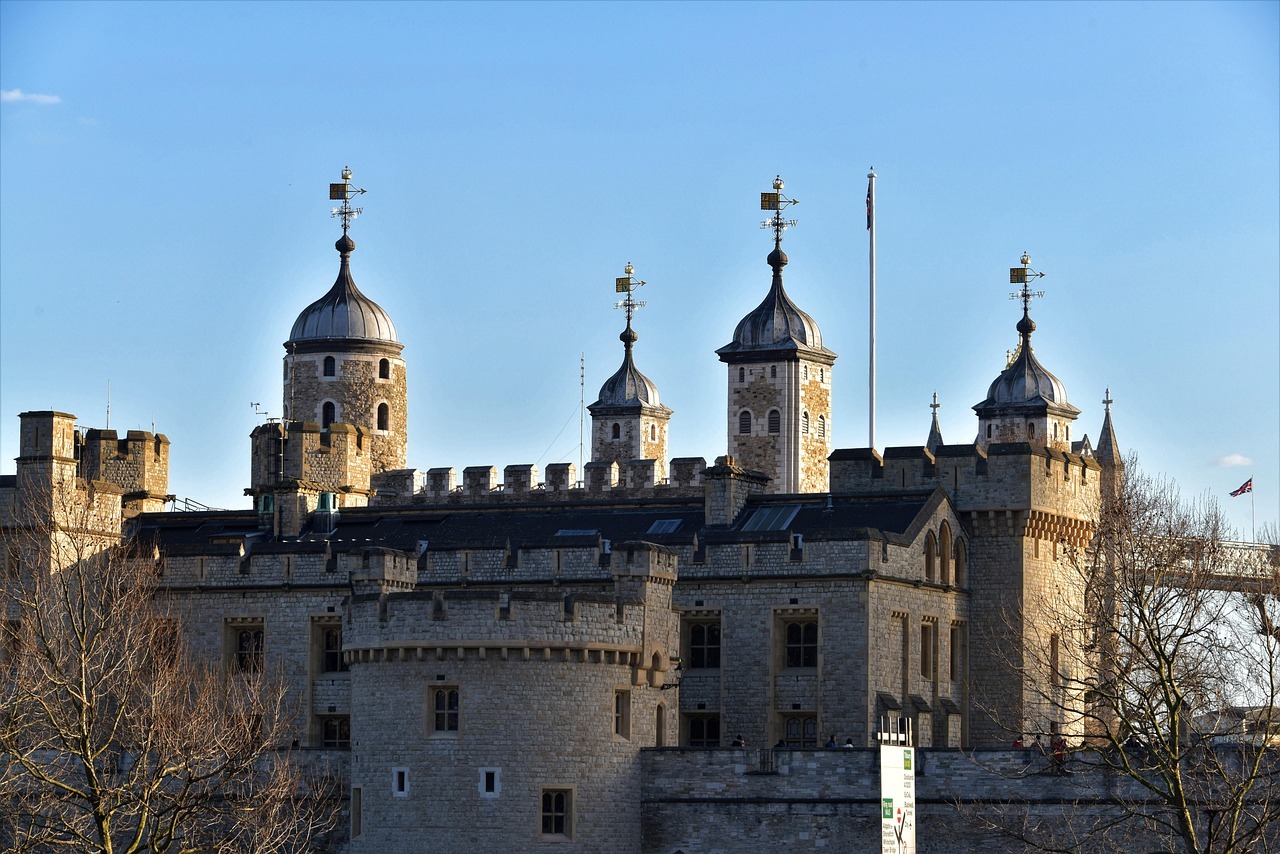 A large castle featuring multiple towers and a prominent clock tower against a clear blue sky