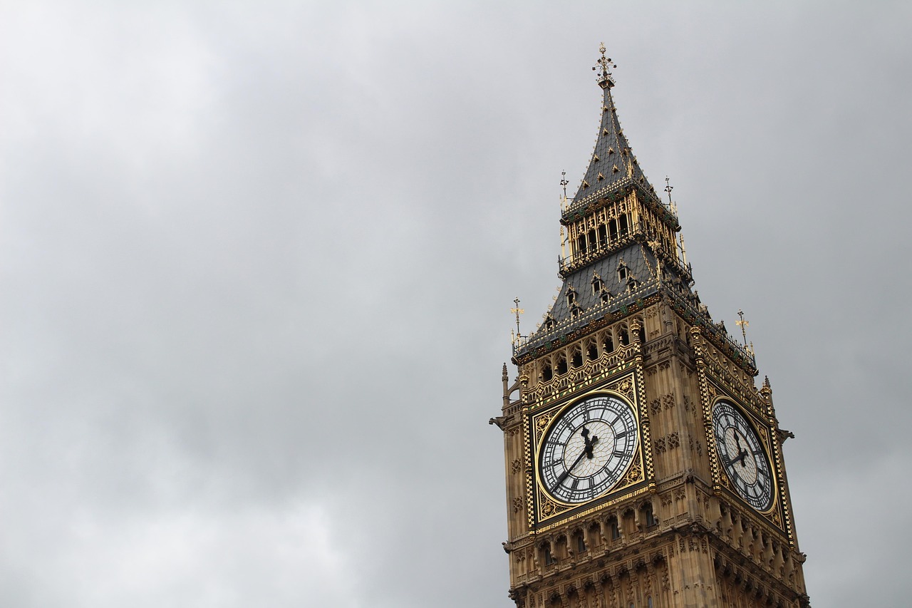 A large clock tower featuring a prominent clock on its face, set against a clear blue sky